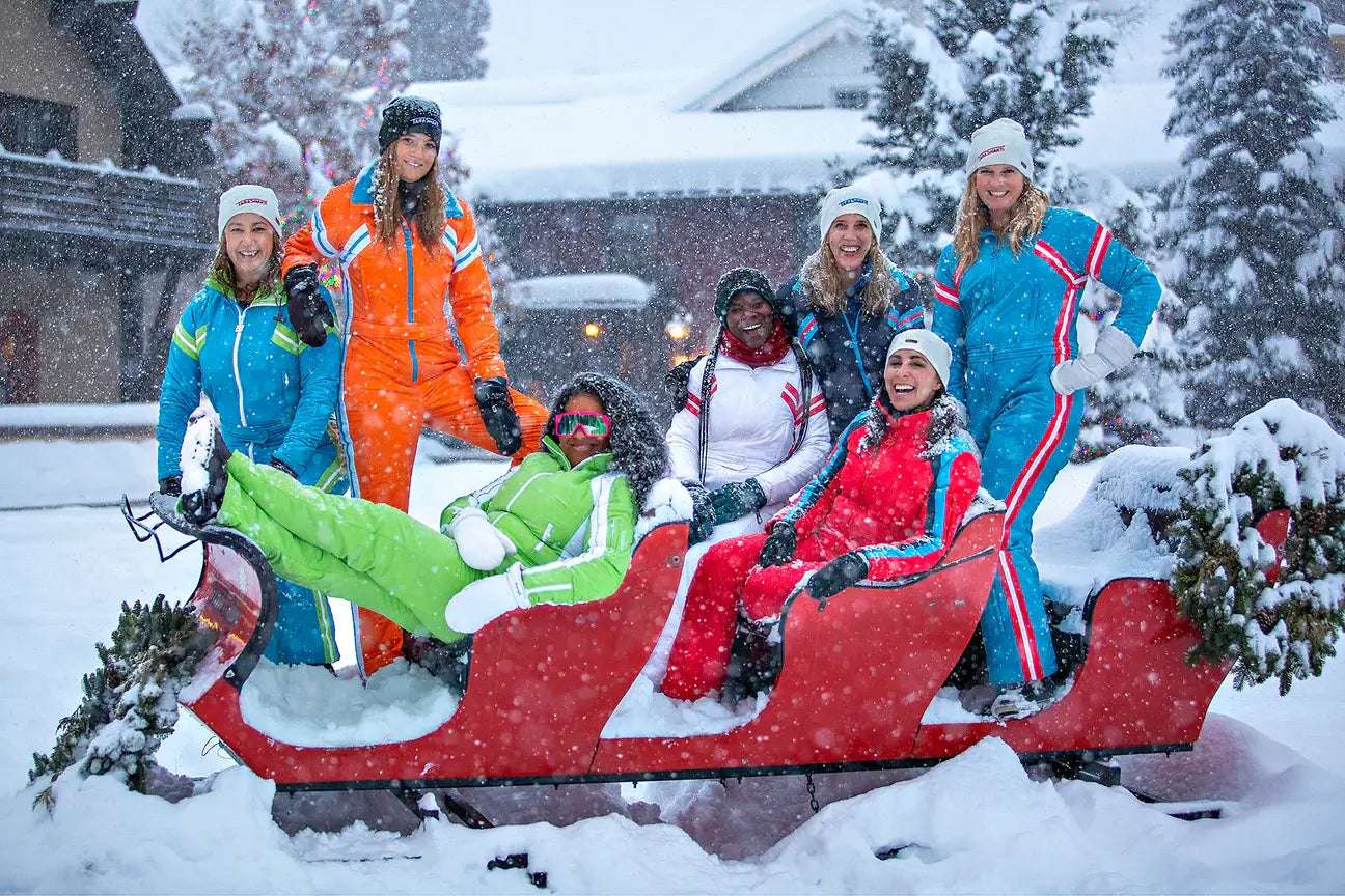 happy women wearing tara shakti sustainable designer one-piece skiing suits