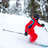 woman wearing tara shakti sustainable designer one-piece skiing suit on a slope