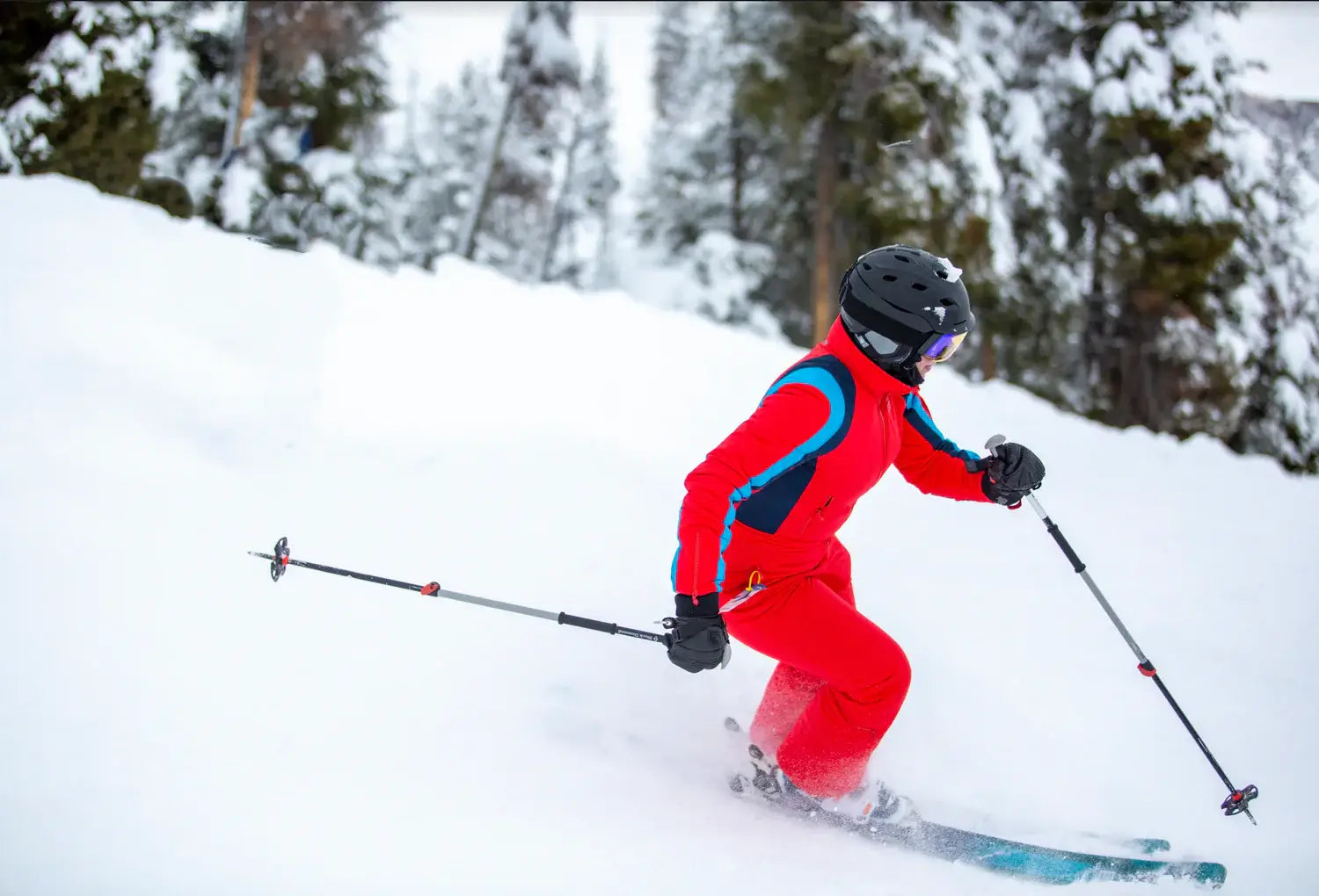 woman wearing tara shakti sustainable designer one-piece skiing suit on a slope