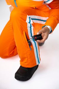 model wearing tara shakti one-piece ski suit gloria variant orange white hidden pocket