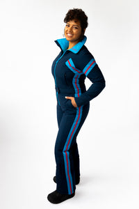 side view model wearing tara shakti one-piece ski suit bonnie variant dark and light blue