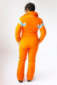 model wearing tara shakti one-piece ski suit gloria variant orange white back