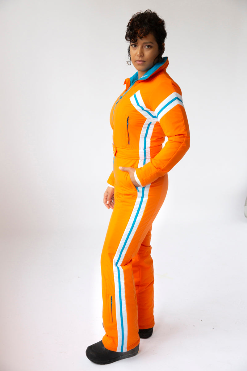 side view model wearing tara shakti one-piece ski suit gloria variant orange white