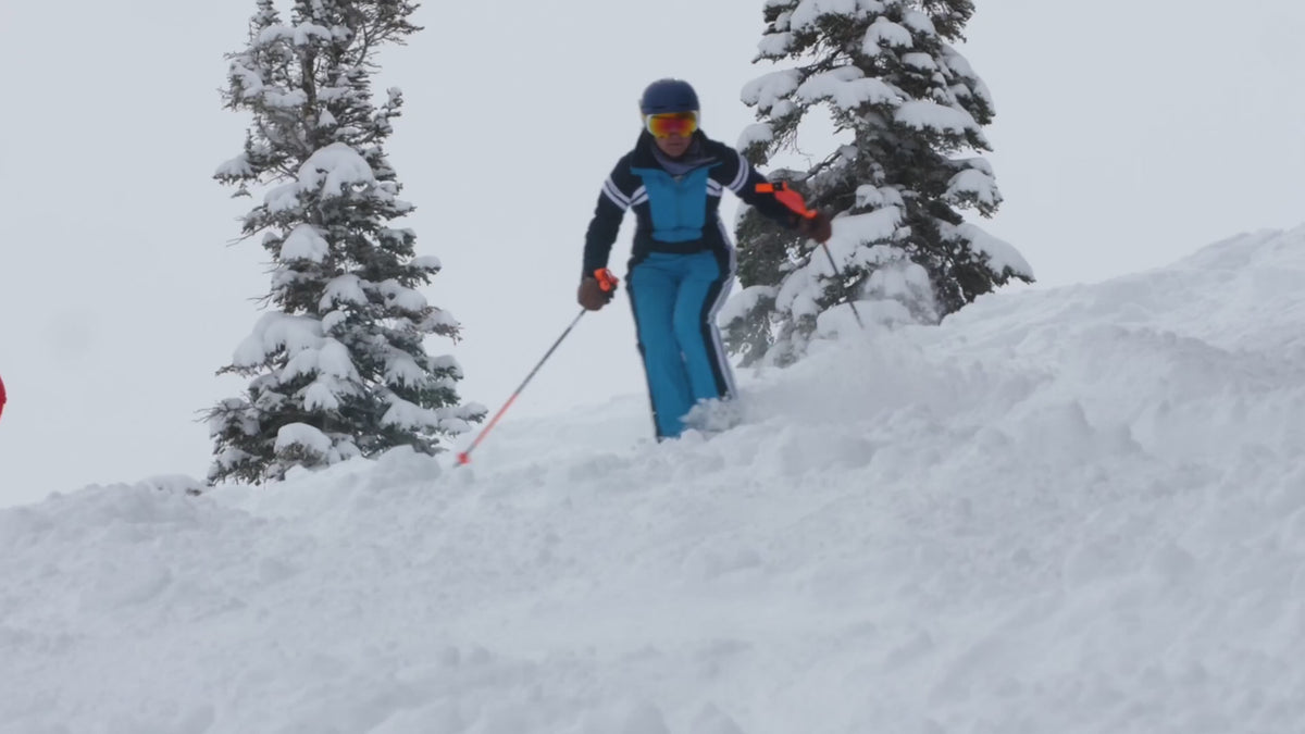 woman skiing in a blue designer vintage-inspired ski suit